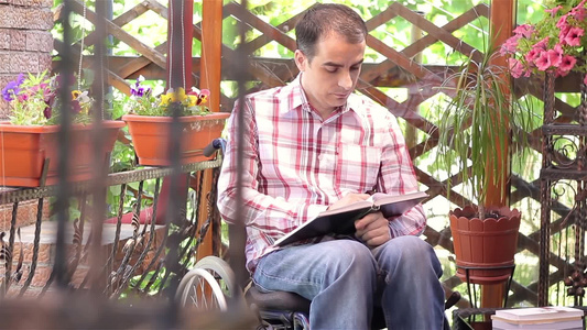 残疾人坐在轮椅上阅读书籍视频