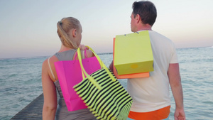 带着购物袋在海上码头上行走的年轻人和女人19秒视频
