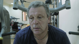 累汗的男人在运动机械装置之间休息和呼吸14秒视频