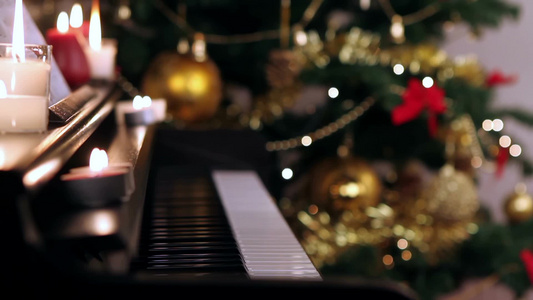 圣诞树附近有燃烧蜡烛的钢琴键盘视频