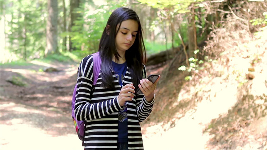 女孩在森林里看手机视频