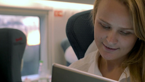 年轻的金发女职员乘火车旅行时使用电子平板电脑娱乐消遣20秒视频