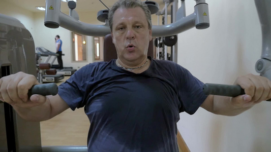在健身房的机器上训练胸部肌肉的男人视频