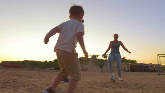 晚上家庭成员在沙滩上踢足球视频