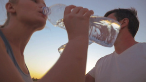 年轻的男人和女人从塑料瓶中饮水21秒视频