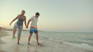 夫妇穿着脚蹼慢走在海边26秒视频