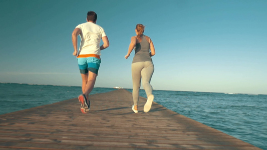 两个年轻男女朋友沿着码头跑步运动视频