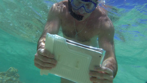 浮潜的年轻人在水下用平板电脑拍摄珊瑚礁20秒视频