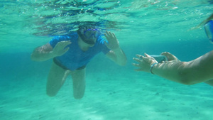 在潜水的游客在水下用防水的智能手机拍照20秒视频