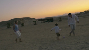 日落沙滩上一家三口玩球8秒视频