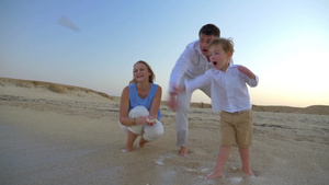 一家三口在海滩上嬉戏捡贝壳9秒视频