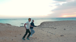 年轻男女在海滩上慢跑并享受音乐12秒视频