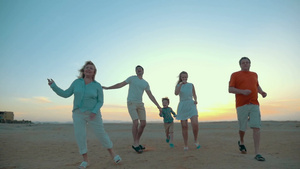 父母和孩子还有祖父母在海滩上自由地奔跑跳跃13秒视频