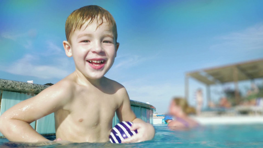 小男孩在游泳池对着相机泼水玩耍[游玩]视频