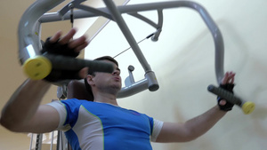 年轻人在健身房使用胸压机锻炼14秒视频
