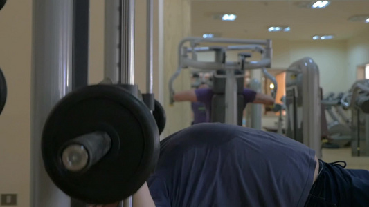 中年男子在健身中心使用胸部按压运动机缓慢运动视频
