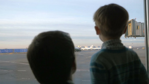 儿子和父亲在机场窗口看着卡车和飞机43秒视频