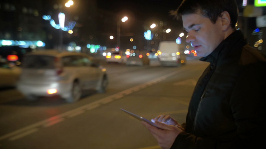 年轻人站在路边用平板电脑上网发信息视频