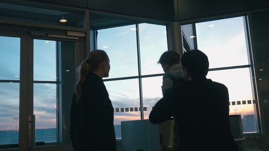 一家人在机场休息室窗口看飞机视频
