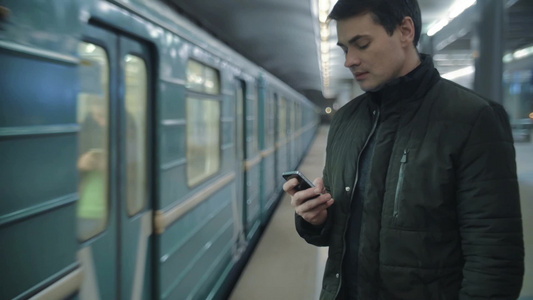 地铁站的男子使用手机打字[品牌手机]视频