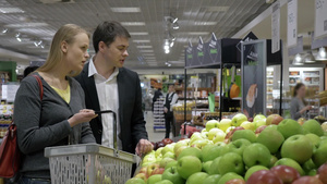一对年轻夫妇在超市里购买苹果22秒视频