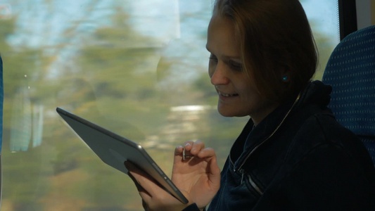 乘坐火车的女人使用平板电脑打字[乘座]视频