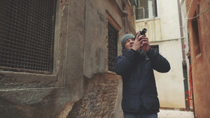 一个男人在威尼斯看着破旧的墙壁用胶片相机拍摄59秒视频