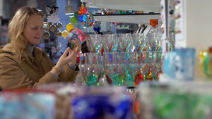 威尼斯玻璃商店里的年轻女人在挑选装饰华丽图案玻璃杯17秒视频