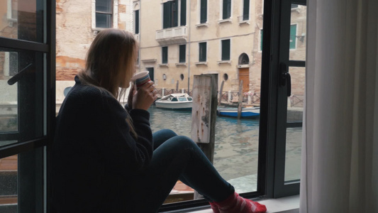 女人坐在窗台上喝着热咖啡视频