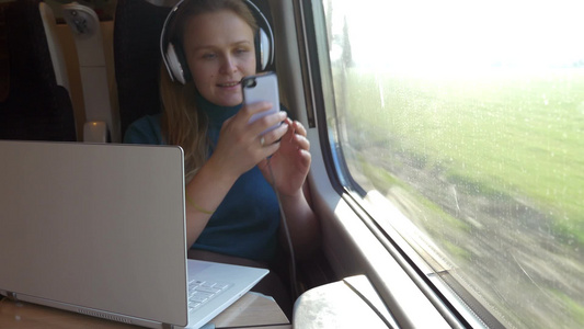 乘火车旅行的女人使用手机拍摄外景视频