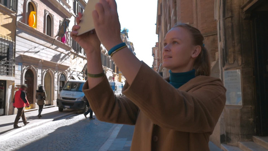 女游客用平板电脑拍摄罗马街道上古老建筑的照片视频
