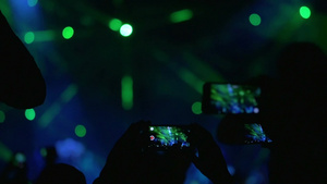 人们拿着智能手机拍摄舞台上的表演14秒视频