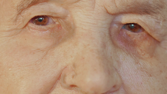 特写镜头拍摄一位老年妇女的棕色眼睛和皱纹的皮肤视频