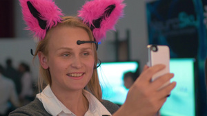 女人戴着神经猫的耳朵用手机自拍而脑电波控制的小工具显示情绪与耳朵的运动18秒视频