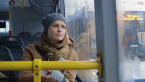 冬天一个年轻女人拿起手机看着公共汽车窗外14秒视频