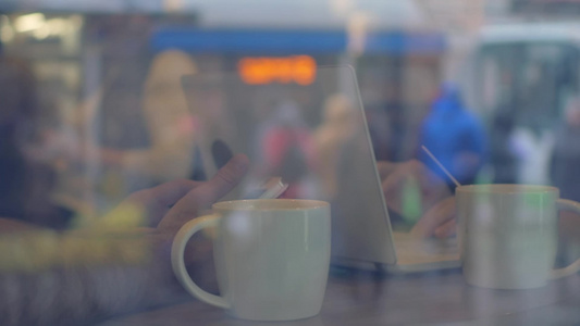 男女在咖啡馆喝茶时使用笔记本电脑的慢动作视频
