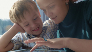 年轻的母亲和孩子在火车上玩平板电脑29秒视频
