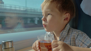 小男孩在火车上看着窗外喝茶25秒视频