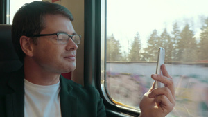 眼镜男在火车上使用智能手机视频聊天16秒视频