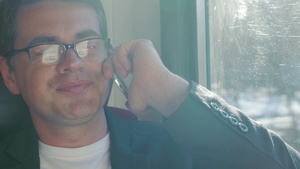 戴眼镜的年轻人在乘火车旅行时打电话36秒视频