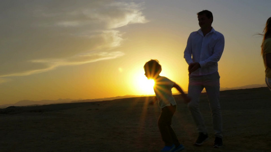 年轻夫妇和他们的儿子在海滩上跳舞视频