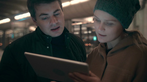 年轻男女站在地铁站手里拿着平板电脑正在处理生意11秒视频