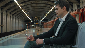 年轻的商务人士正在等地铁时侯用智能手机打发时间15秒视频