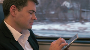 年轻白领坐在行驶的火车上用平板电脑写信息23秒视频