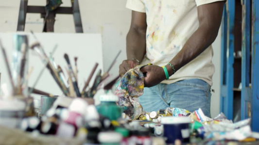 艺术工作室的年轻黑人正在清洁工具[二十多岁]视频