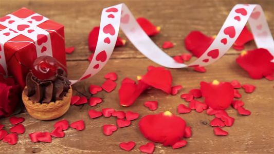 木制背景上的巧克力蛋糕玫瑰和烛光礼物视频