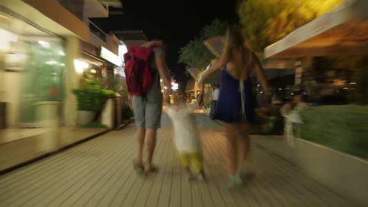 夜晚在城市道路上行走的一家人视频