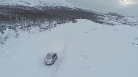 在大雪纷飞的道路上驾驶的越野车视频