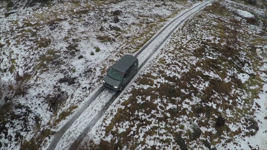 空中拍摄在寒冷的雪乡行驶的汽车视频