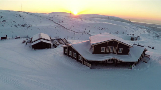 日落时雪场和山丘的冬季滑雪中心地区视频